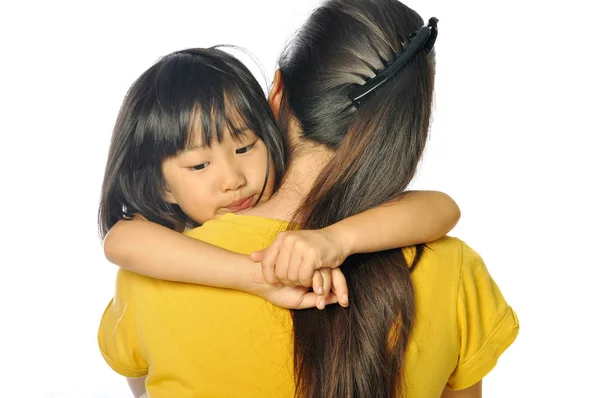 Sad asian little girl hugging parent around shoulders — Stock Photo, Image