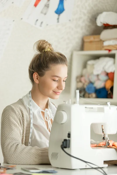 Portrait of a beautiful woman at sewing machine — Stock Photo, Image