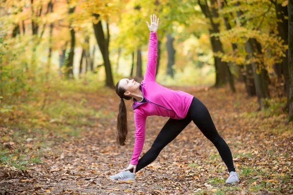 Yoga outdoors: Utthita Trikonasana pose — Stock fotografie