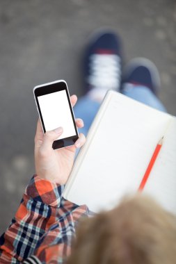 Bir smartphone karşı açık bir defterini tutan öğrenci