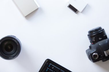 White desk with a professional camera and accessoires