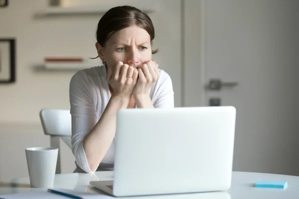 Portret van een jonge vrouw aan balie met laptop, angst — Stockfoto