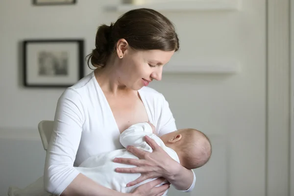 Portrait of a young attractive woman breastfeeding a child — Stock Photo, Image
