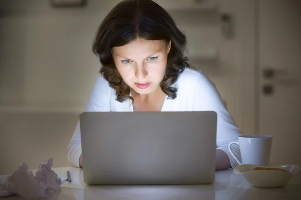 Retrato de uma mulher na mesa trabalhando com um laptop, tarde da noite — Fotografia de Stock