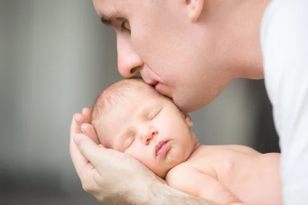 Genç adam onun avuç içi tutan yeni doğmuş, öpüşme — Stok fotoğraf
