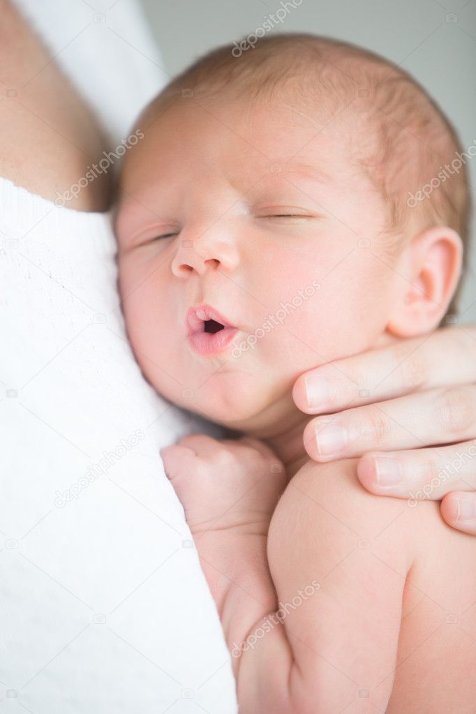 Portrait of a cute newborn hold at mother s breast