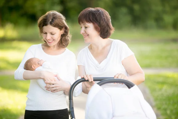 Mamma e nonna che camminano nel parco con neonato — Foto Stock