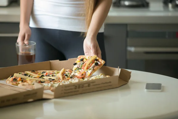 Vrouwelijke handen nemen een plak van pizza uit het vak — Stockfoto