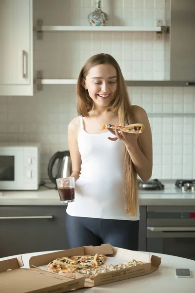 Portrait of smiling girl standing, holding a slice of pizza — Stock Photo, Image