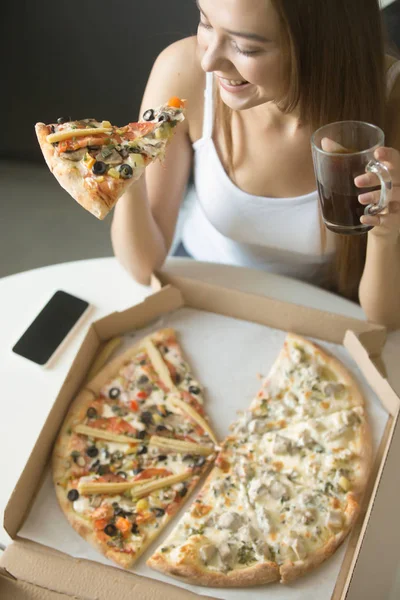 Молодая улыбающаяся женщина с кусочком пиццы — стоковое фото