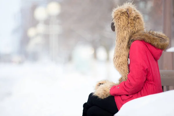 Samotna kobieta siedzi na ławce na zewnątrz w okresie zimowym — Zdjęcie stockowe