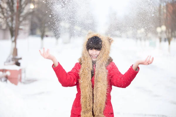 Mujer lanzando nieve en el parque de invierno —  Fotos de Stock