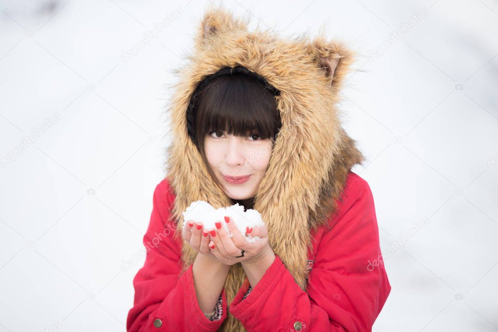 Female blowing snow in winter park