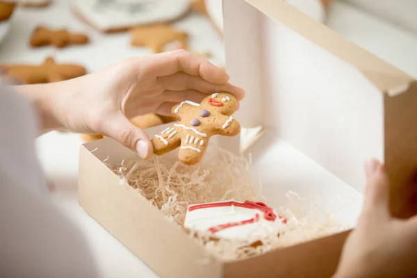 Close up de gingerman de embalagem de mão de confeiteiro em uma caixa — Fotografia de Stock