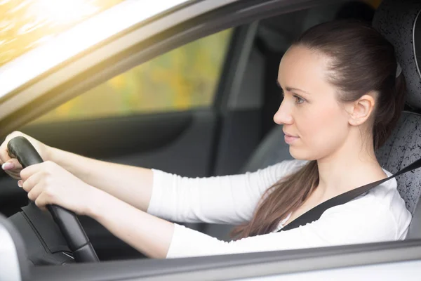 Young female driver looking at the side view mirrors — Stock Photo, Image