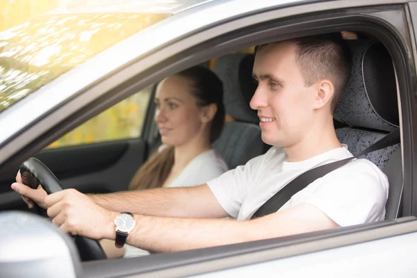 Ung man körning och kvinna sitter nära i bilen — Stockfoto