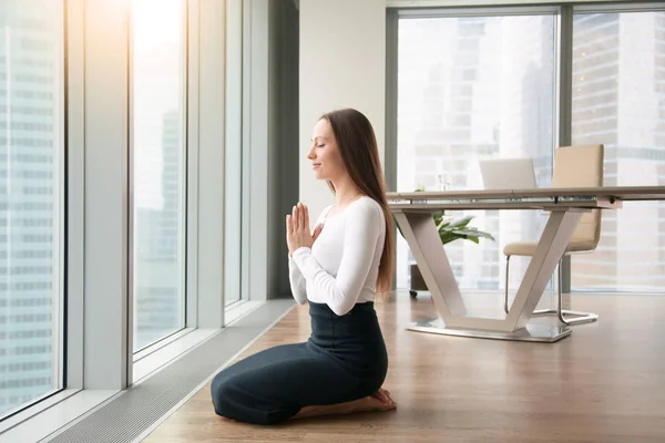 Молодая женщина, практикующая йогу в офисе — стоковое фото