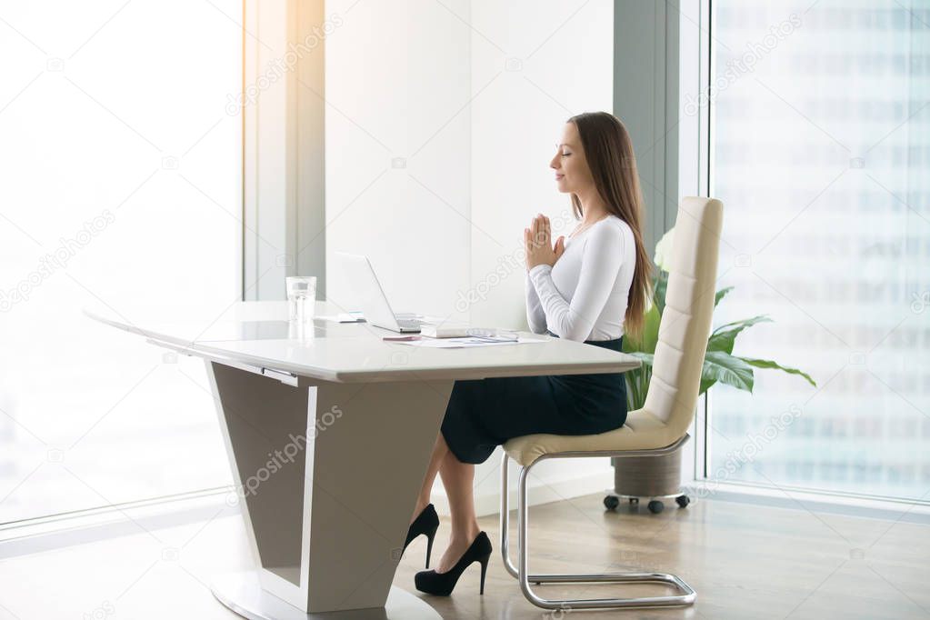 Young woman meditating at the office desk