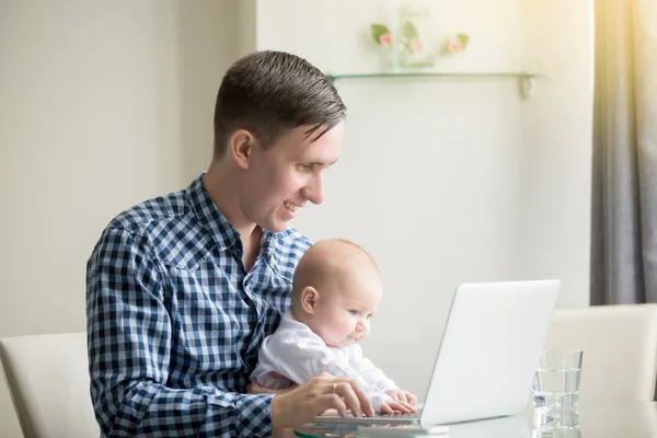 男子和一名婴儿在笔记本电脑工作 — 图库照片