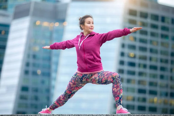 Woman wearing pink in Warrior 2 pose — Stock Photo, Image