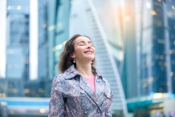 Portrait of a young happy woman at the city street