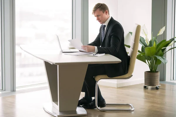 Businessman working with laptop and paper at the modern desk — Stock Photo, Image