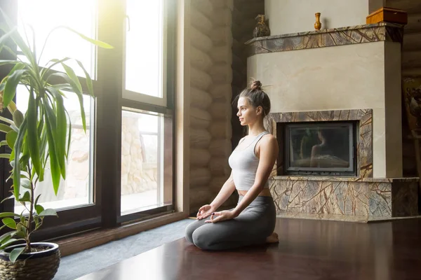 Jonge aantrekkelijke vrouw in vajrasana pose, home interieur CHTERGRO — Stockfoto