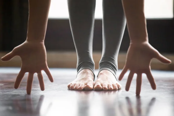 Primer plano de la pose femenina en uttanasana, piernas en pantalones de yoga — Foto de Stock