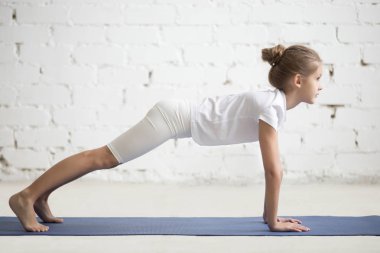 Kız çocuğu phalankasana içinde poz, beyaz stüdyo arka plan