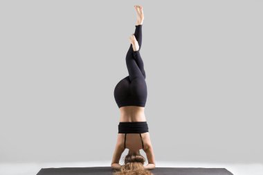 Garuda Sirasana sirsasana poz, gri St genç çekici kadın