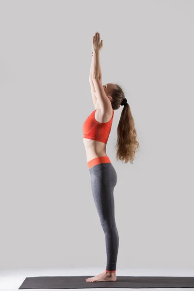 Young attractive woman standing in Tadasana pose, grey studio ba — Stock Photo, Image