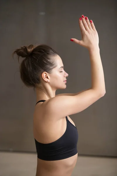 Young attractive woman in meditating pose, grey studio backgroun — Stock Photo, Image