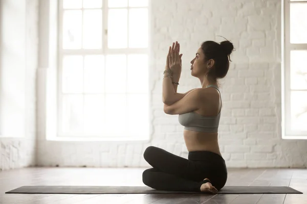 Mujer atractiva joven en pose Gomukasana, loft blanco estudio bac —  Fotos de Stock