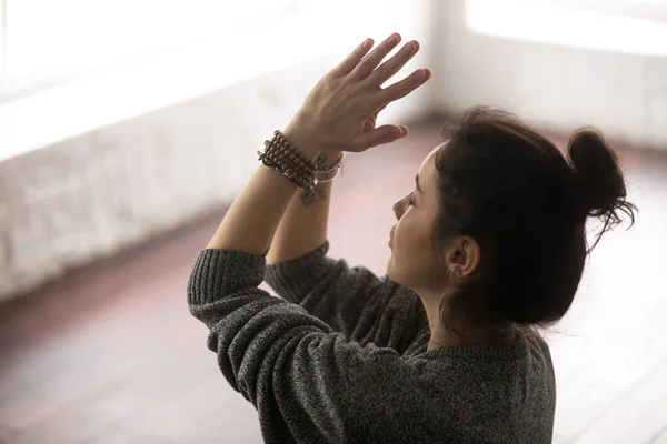 Giovane donna attraente in maglione grigio facendo gesto namaste, s — Foto Stock