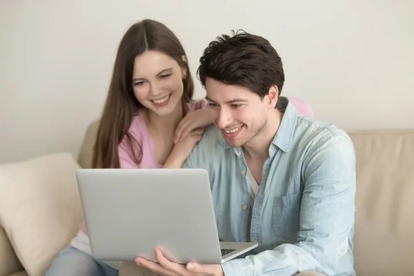 Unga lyckliga paret sittande med bärbar dator, videosamtal, — Stockfoto