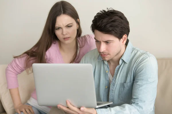 Casal jovem usando computador portátil, tendo problemas, ansioso e — Fotografia de Stock