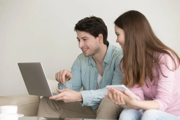 Young man and woman using laptop, tablet, talking, shopping onli — Stock Photo, Image