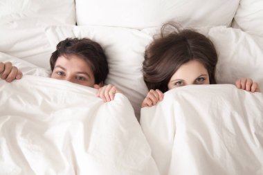 Kameraya bakarak kapsayan altında yatakta yalan Çift