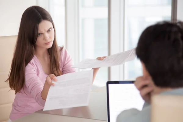 Злий жінка показує чоловікові фінансові документи, бізнес-контракт — стокове фото