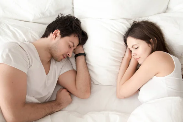 Счастливая молодая пара спит вместе в постели, наслаждаясь сладким сном — стоковое фото
