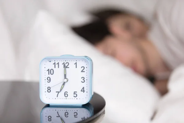 Young couple sleeping in bed next to an alarm clock — Stock Photo, Image