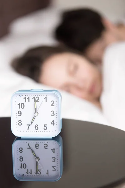 Alarm clock and couple asleep early in the morning, vertical — Stock Photo, Image