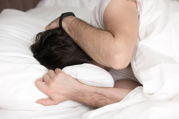 Man die betrekking hebben op hoofd met handen in bed, wakeup of depressie — Stockfoto