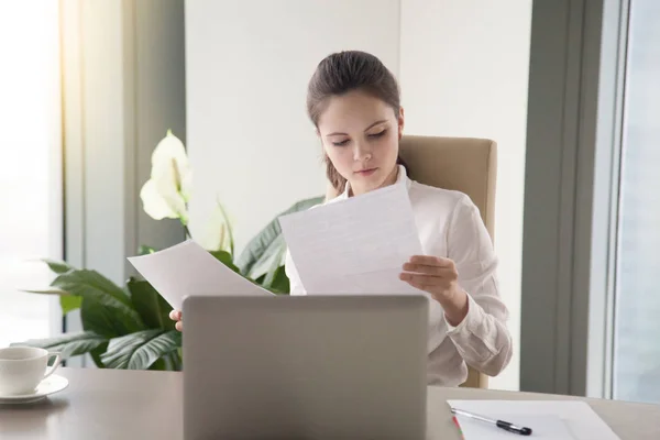 Joven mujer de negocios sentada en el escritorio de la oficina trabajando, mirando thro — Foto de Stock