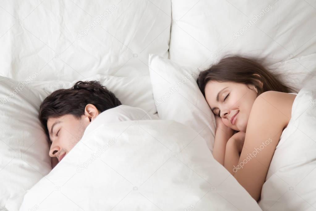 Loving couple sleeping peacefully in comfortable bed, falling as