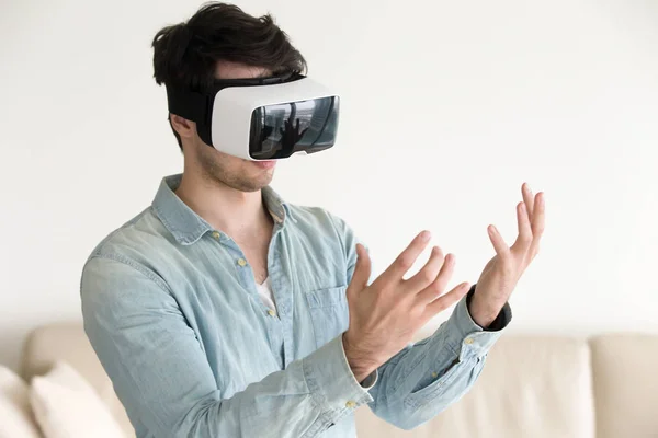 Uomo in realtà virtuale occhiali auricolari guardando le sue mani — Foto Stock
