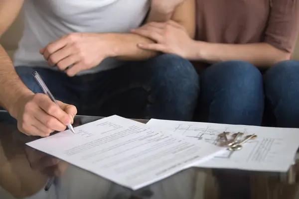 Couple of future apartment owners signing sale purchase agreemen — Stock Photo, Image