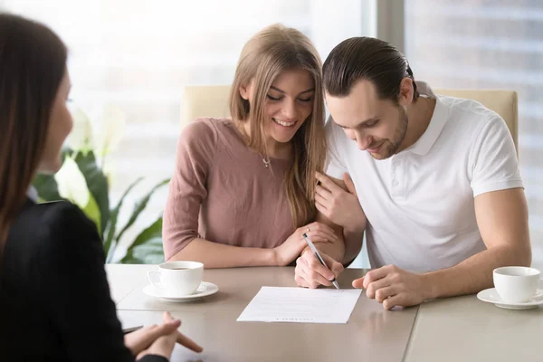 Счастливая семейная пара подписывает документ, берет кредит в банке, insu — стоковое фото