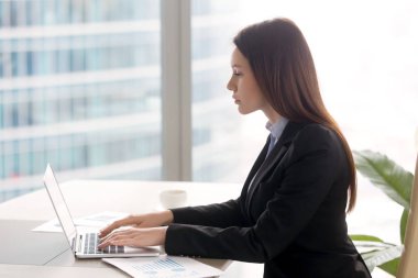 La kullanarak Ofis Masası çalışma başarılı ciddi iş kadını