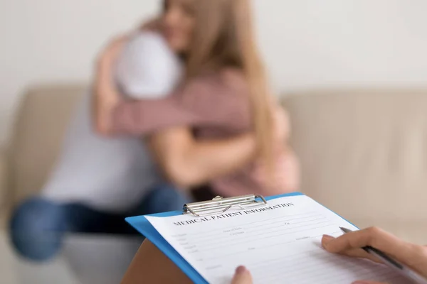 Close up of psychologist writing notes about couple on session — Stock Photo, Image